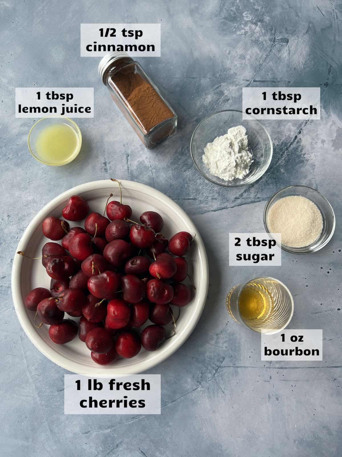 various ingredients for cherry compote legs arranged on a countertop. each ingredient bears a corresponding label