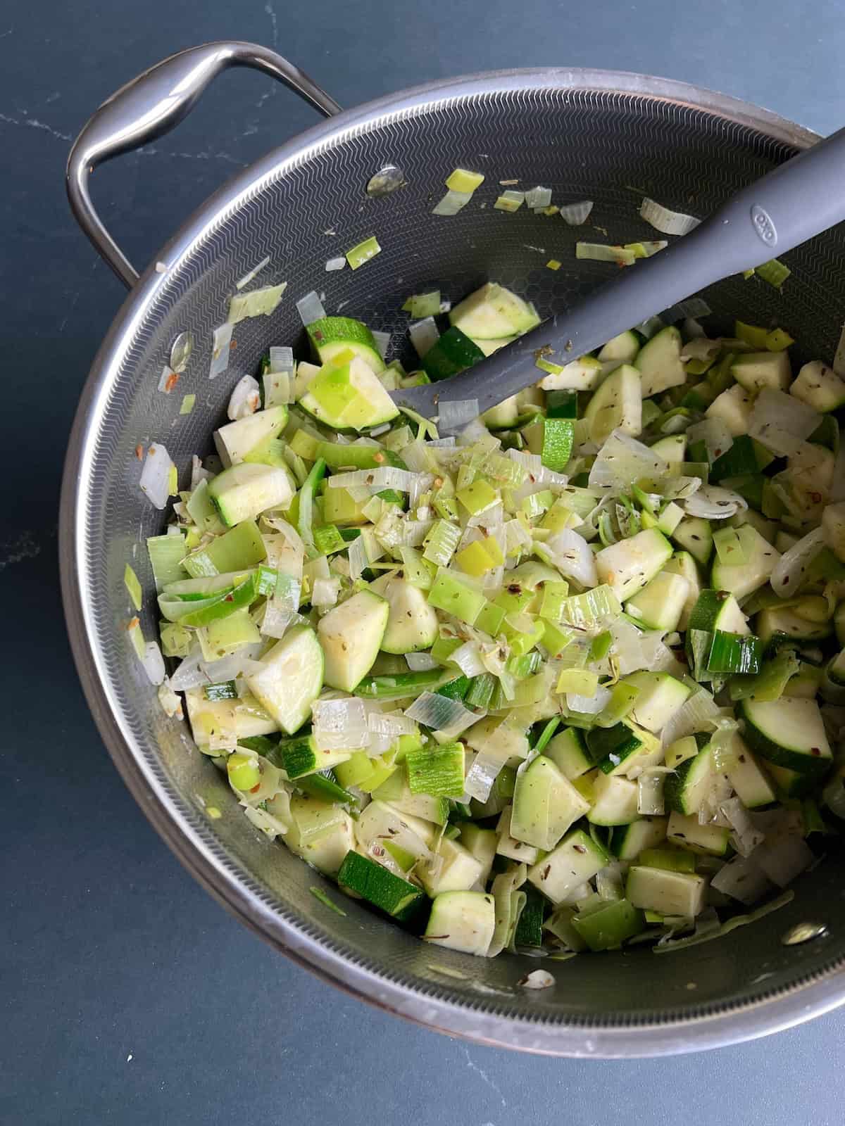 additional vegetables are added to the soup pot