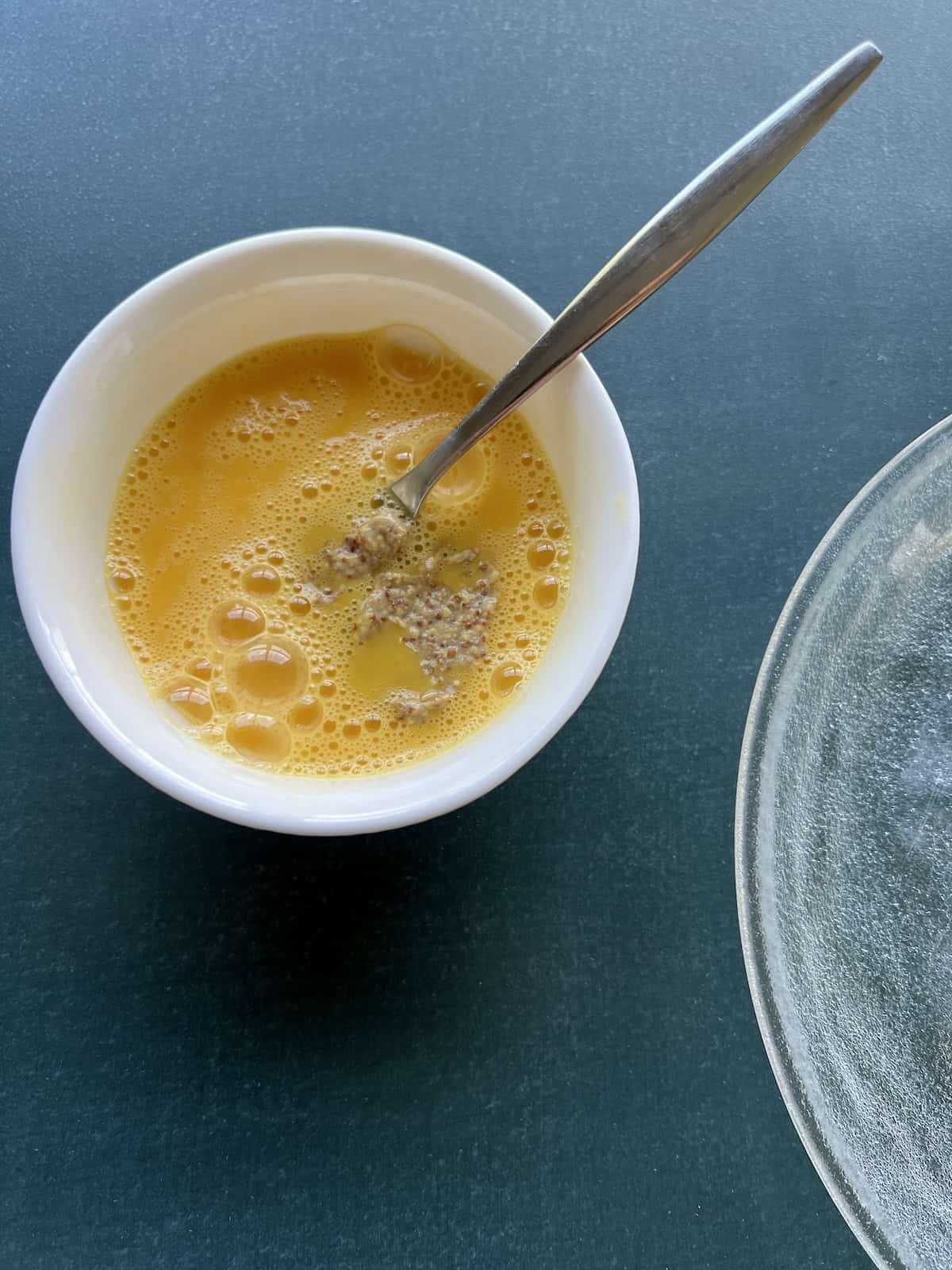 eggs and mustard are whipped together with a fork