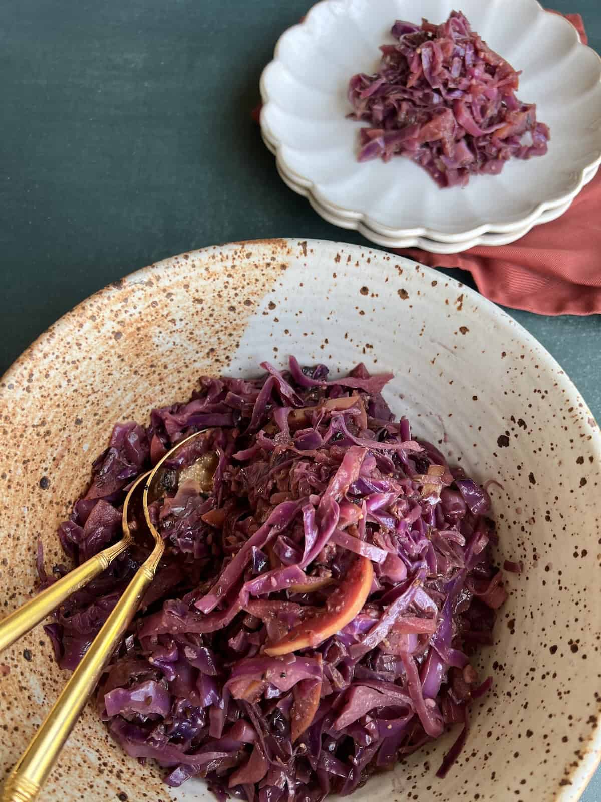 the finished sauteed red cabbage is served from a large bowl on individual serving plates.