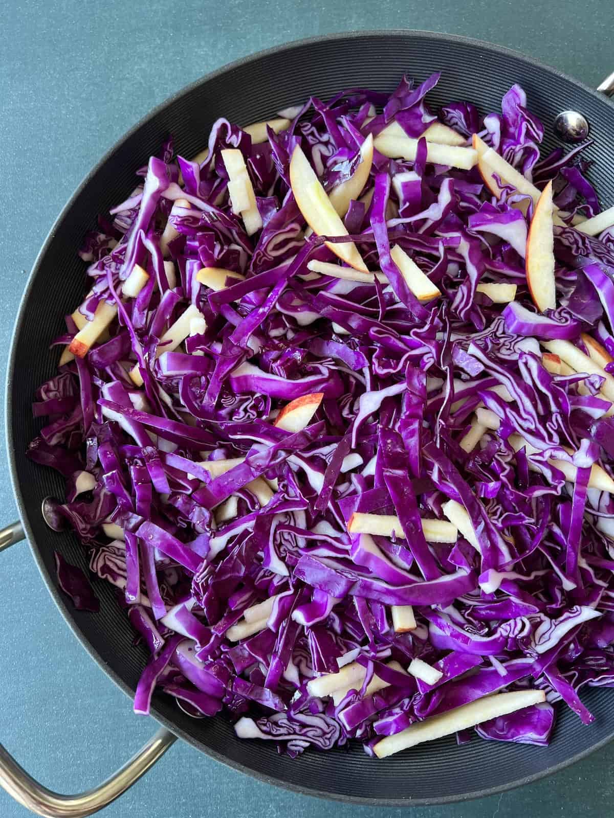the apples and cabbage are tossed together in the skillet