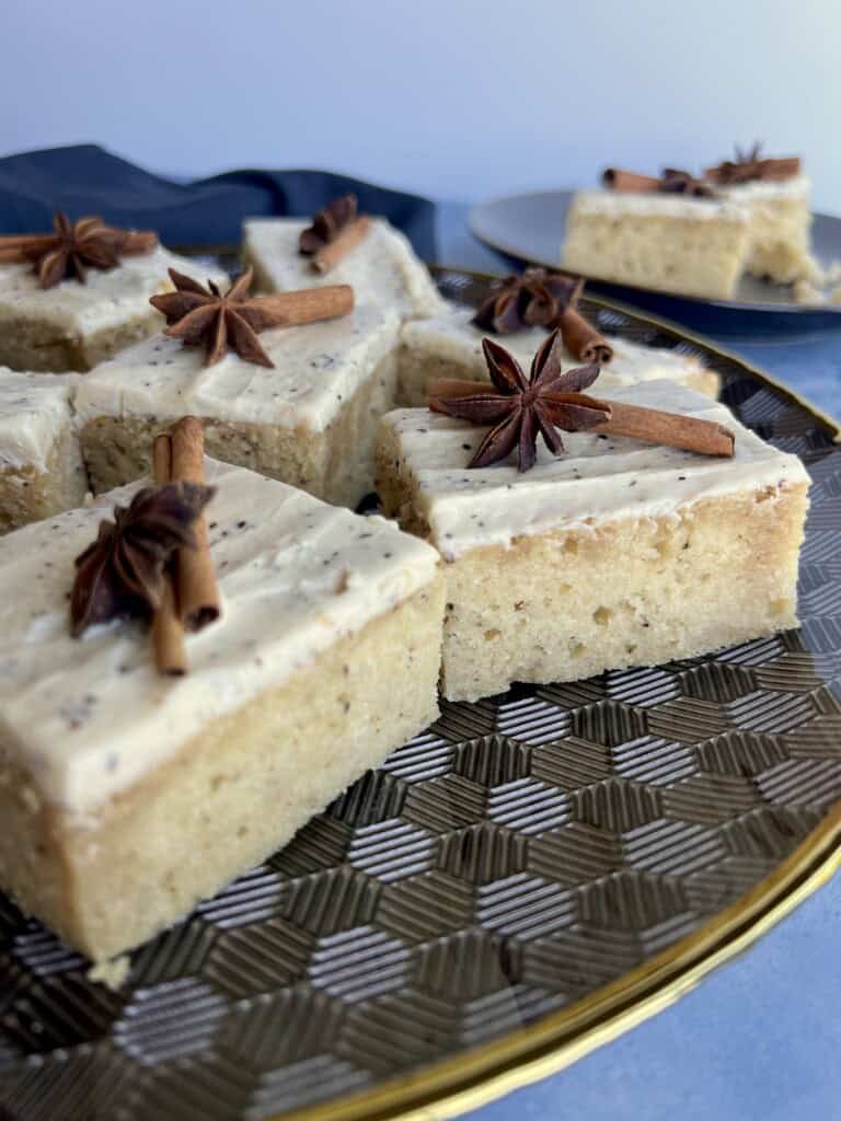 spiced chai cake has flecks of chai tea and spices baked into the crumb and is topped with spiced frosting and whole cinnamon and star anise