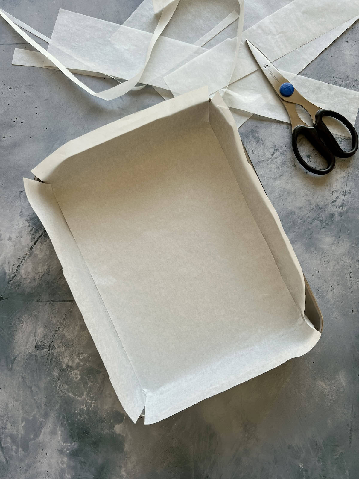 a rectangular cake pan is lined with parchement paper