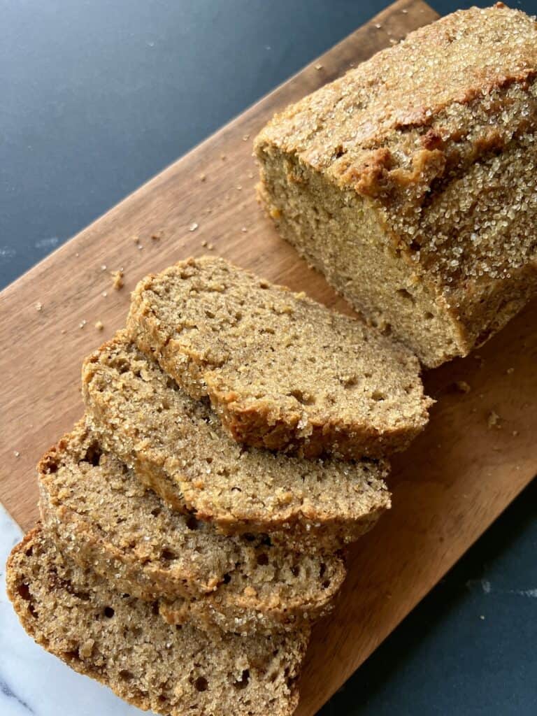 the acorn squash loaf is sliced on a wooden board.