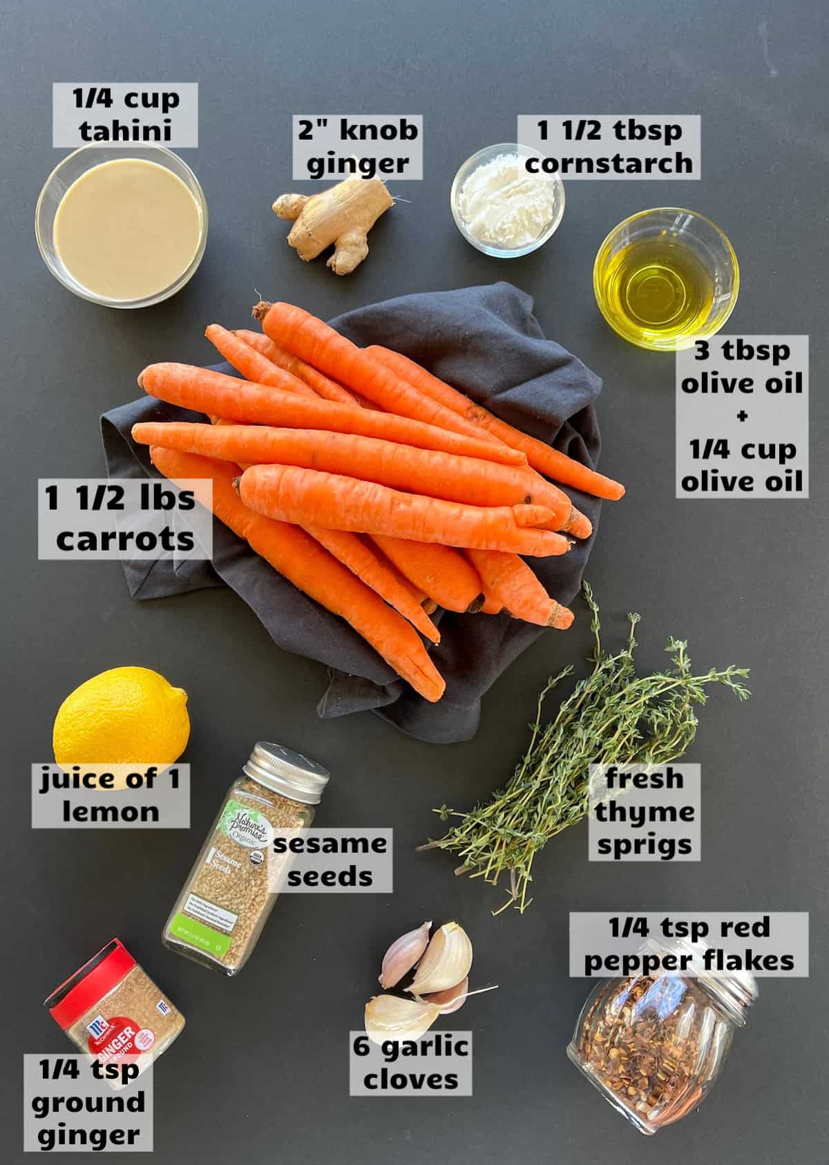 all of the ingredients needed to make roasted carrots with tahini sauce are laid out on a work surface and labeled