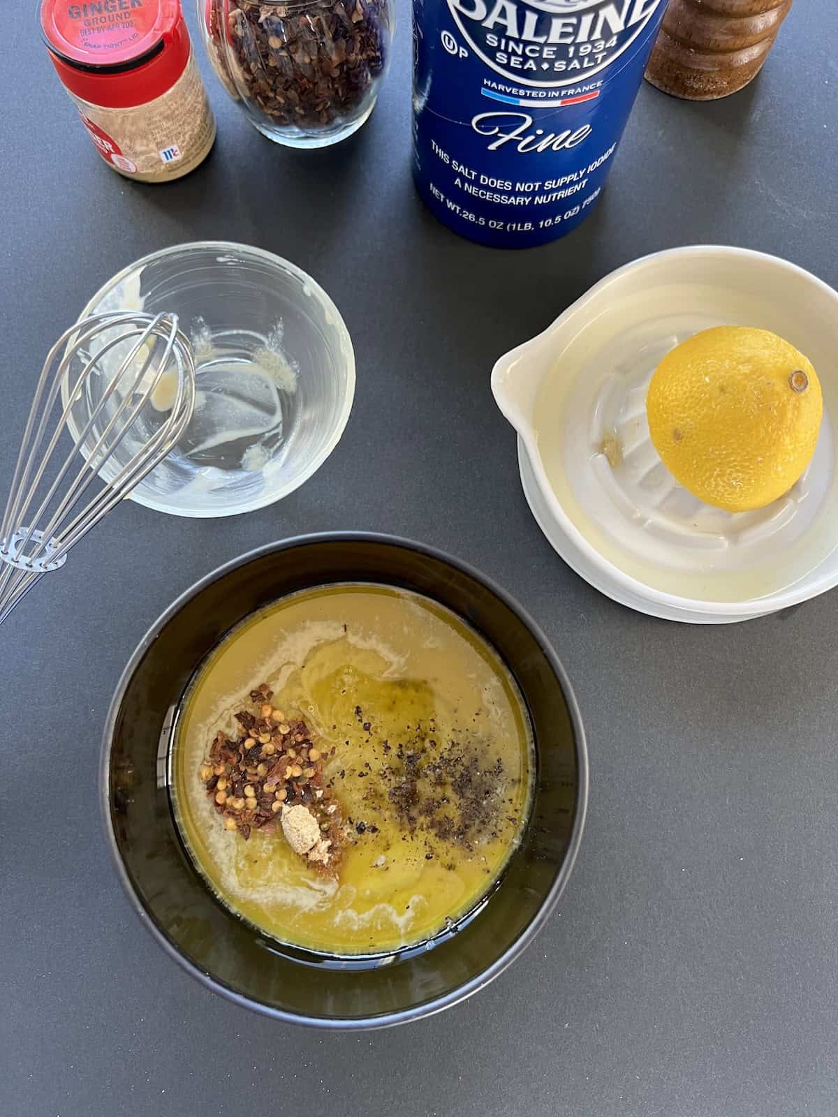 a small bowl containing the tahini sauce ingredients and spices