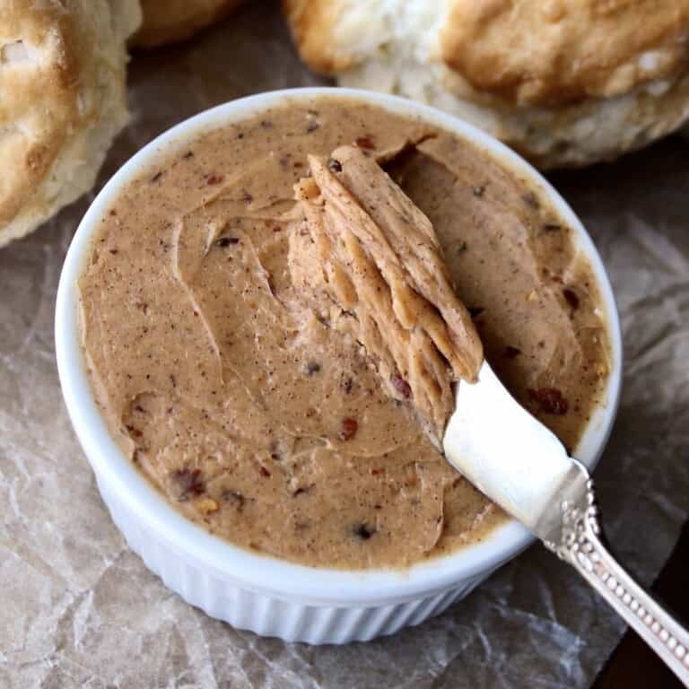 chilled hot honey butter is served from a ramekin, showing it's rich brown coloring flecked with spices