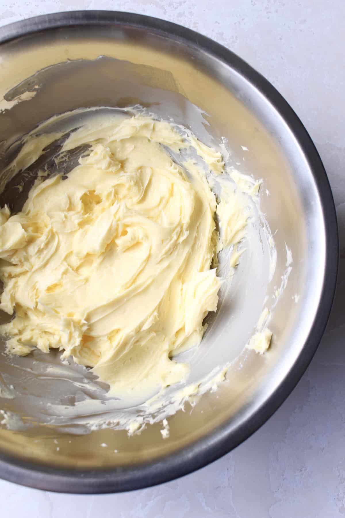 fluffy whipped butter in a large stainless steel mixing bowl