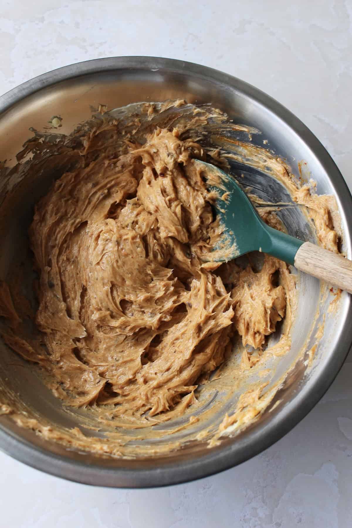 the spices and seasonings are folded into the butter, creating a thick, nutty colored mixture with flecks of spice