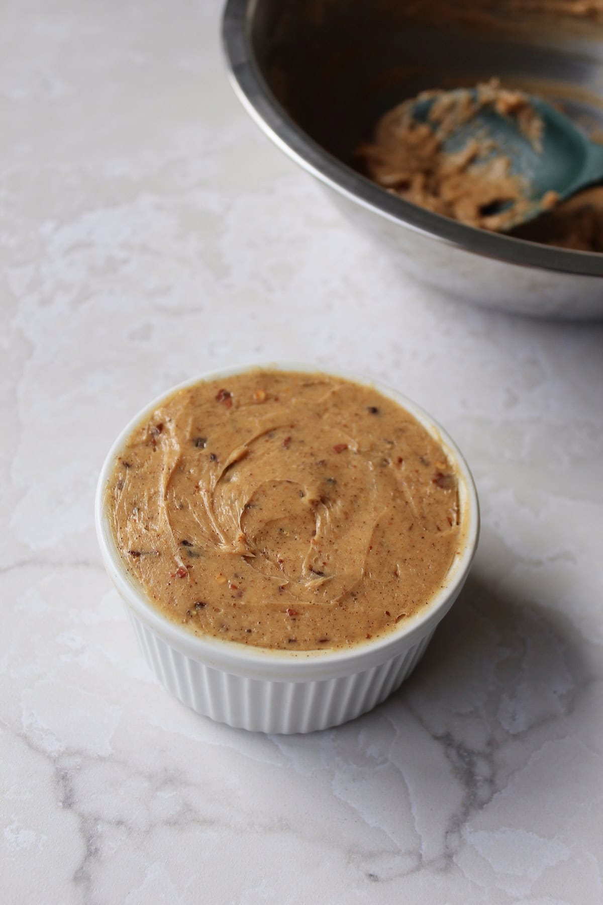 the finished hot honey butter is transferred to a small ramekin and smoothed on top.