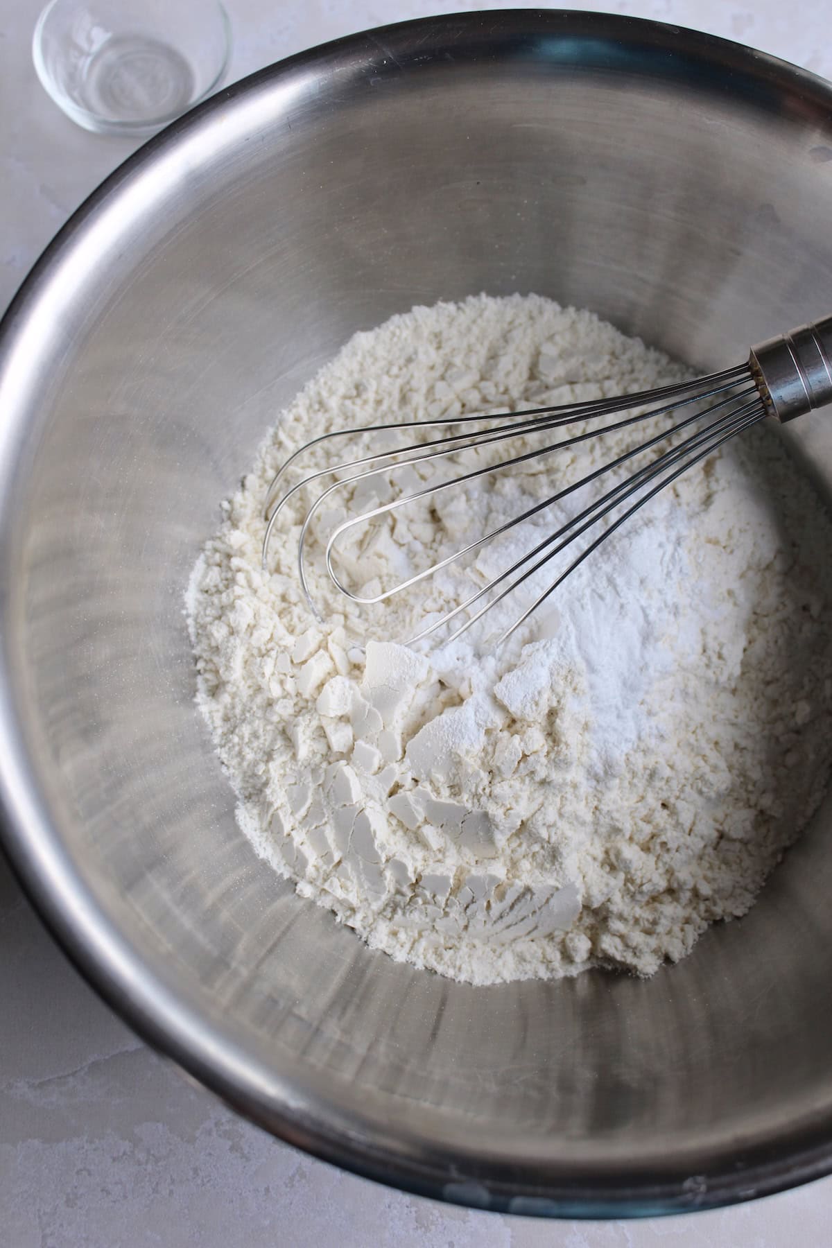 dry ingredients are whisked in a metal mixing bowl