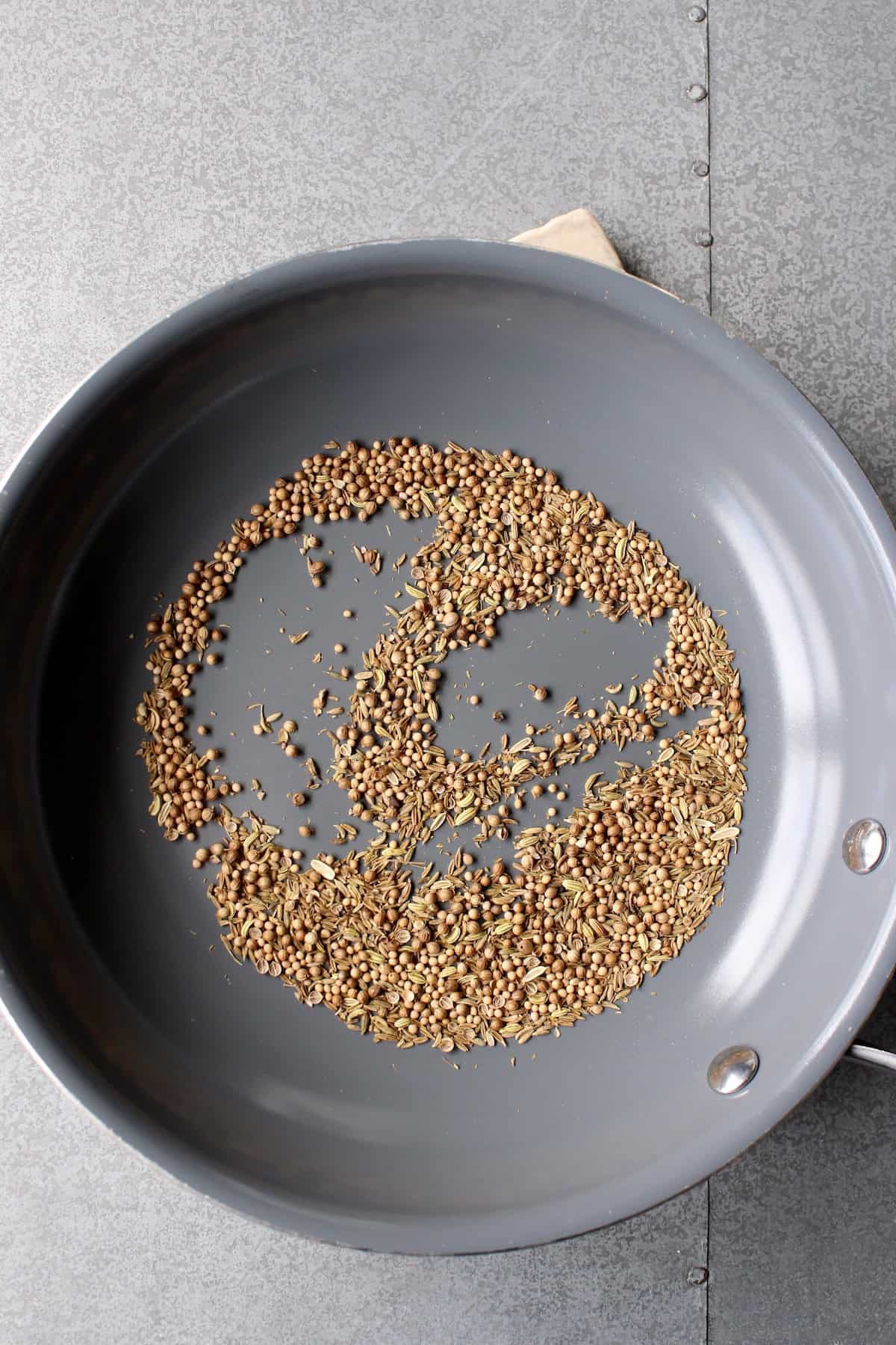 a small frying pan with different whole spices in it