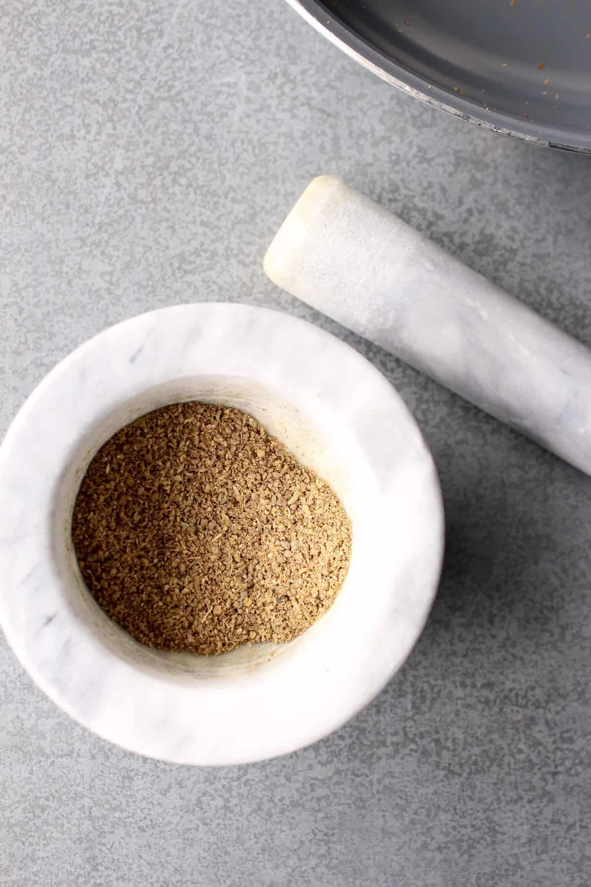 the spices are ground into a fine powder using the mortar and pestle