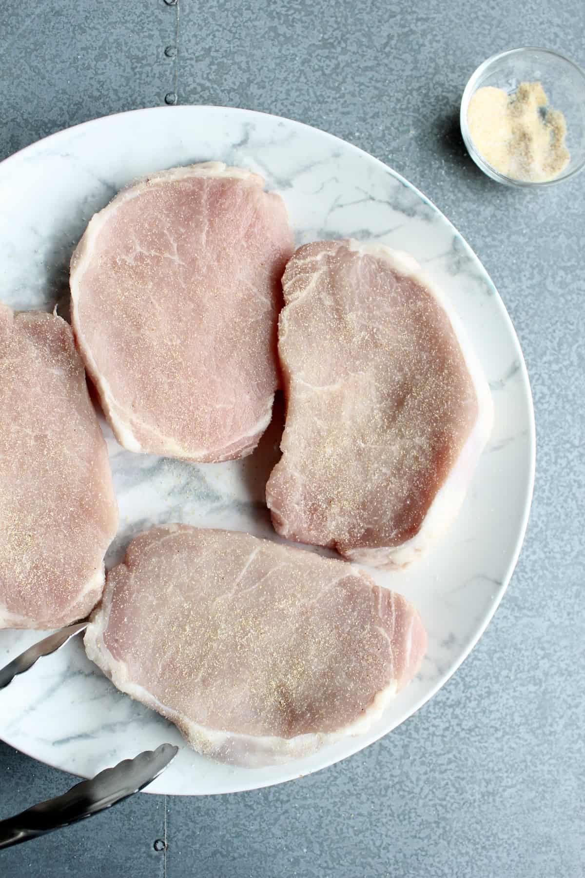 the seasoning mixture is sprinkled on the pork chops