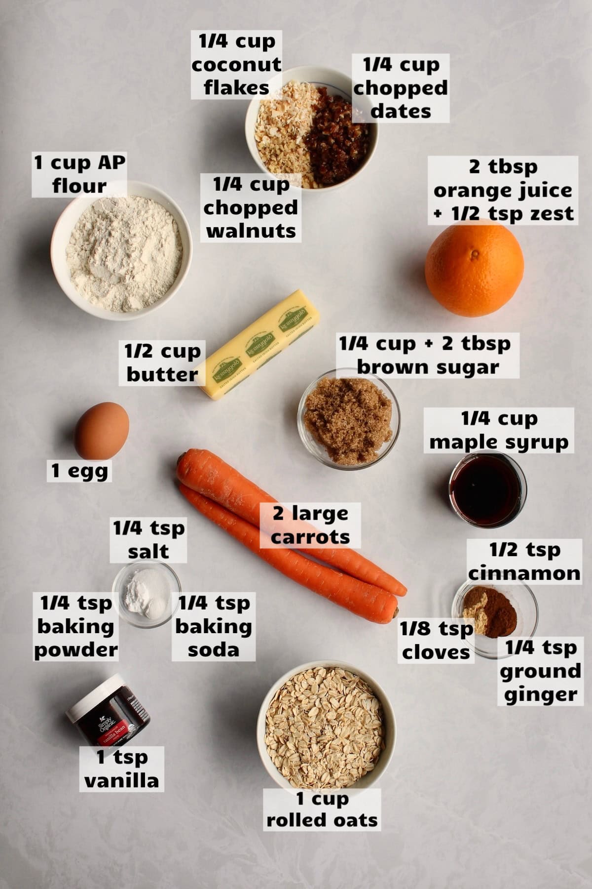 all of the ingredients needed to make oatmeal carrot cake cookies are laid out on a work surface and labeled