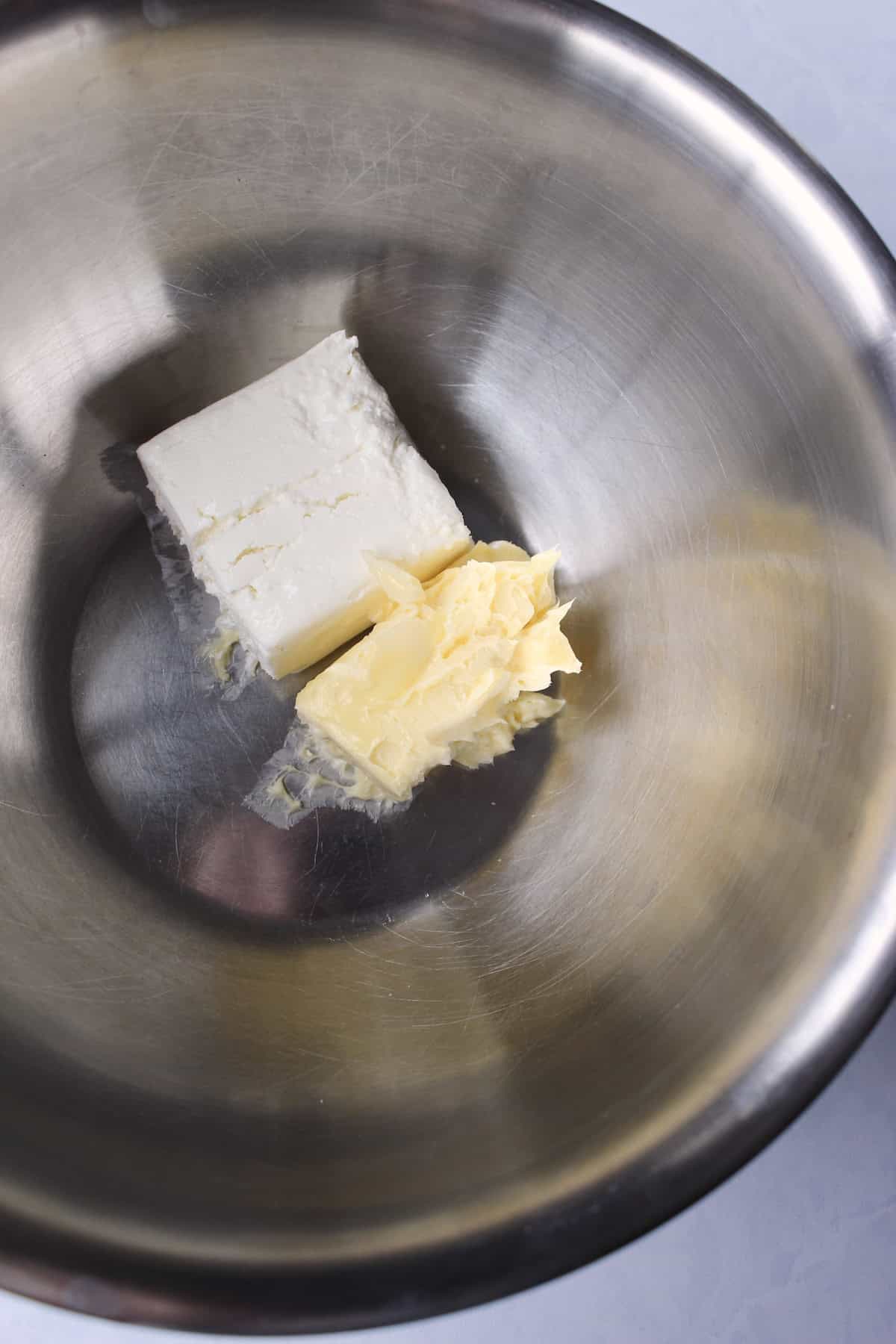 soft cream cheese and butter are placed together in a large mixing bowl