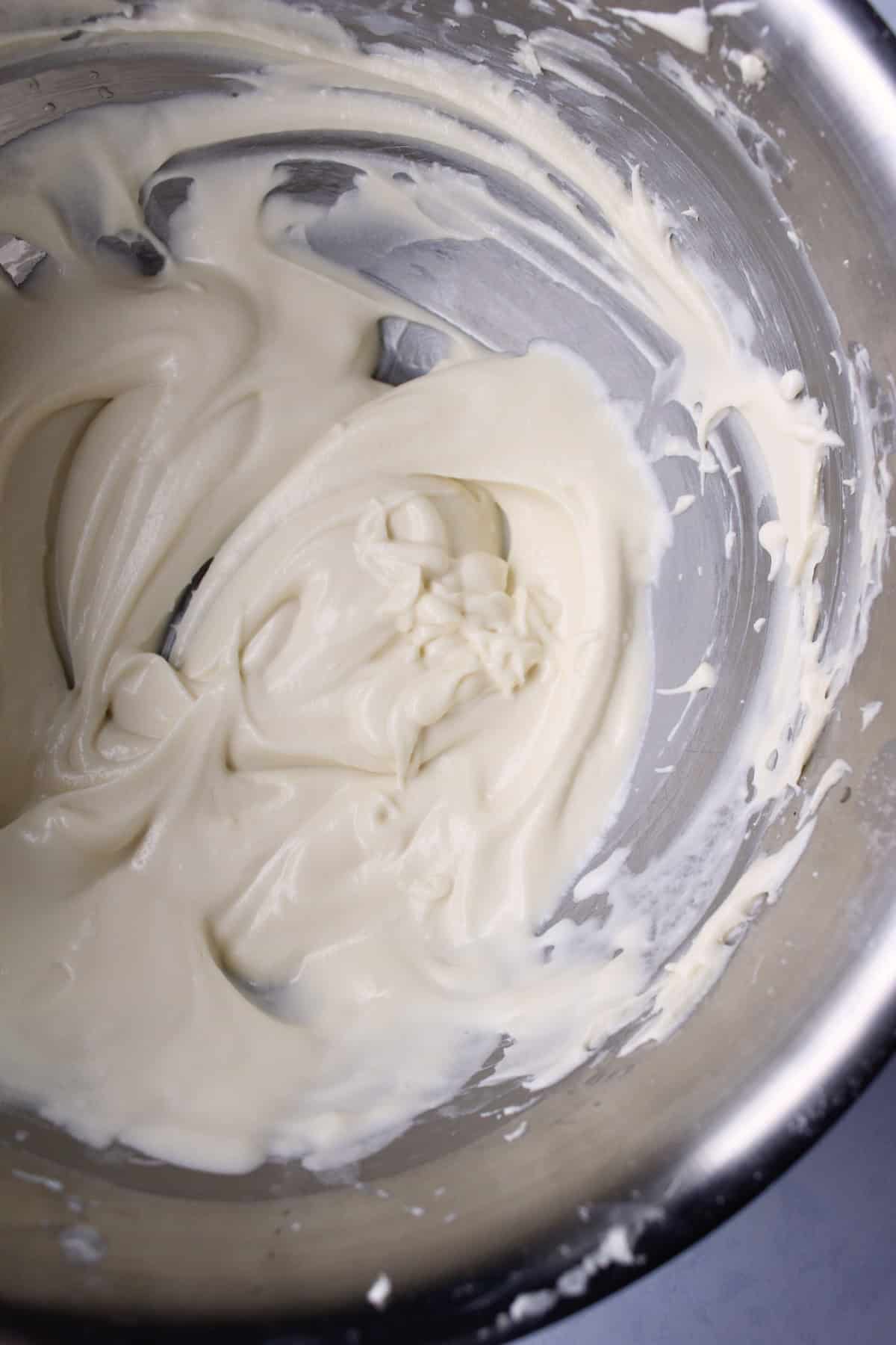 the finished cream cheese icing has a thick, yet pourable consistency and creamy white coloring