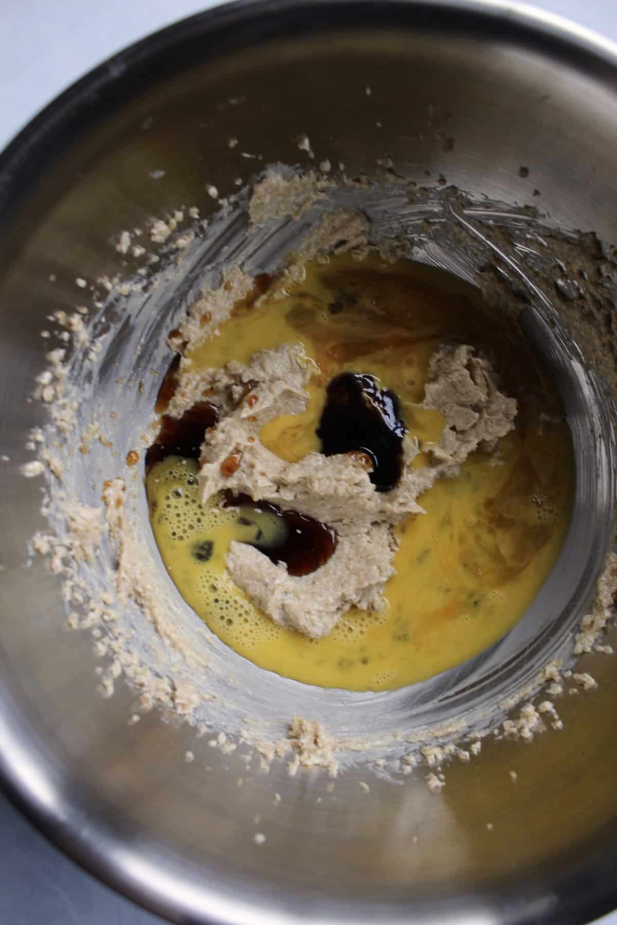 egg and other liquid ingredients are added to the bowl with the butter and sugar mixture