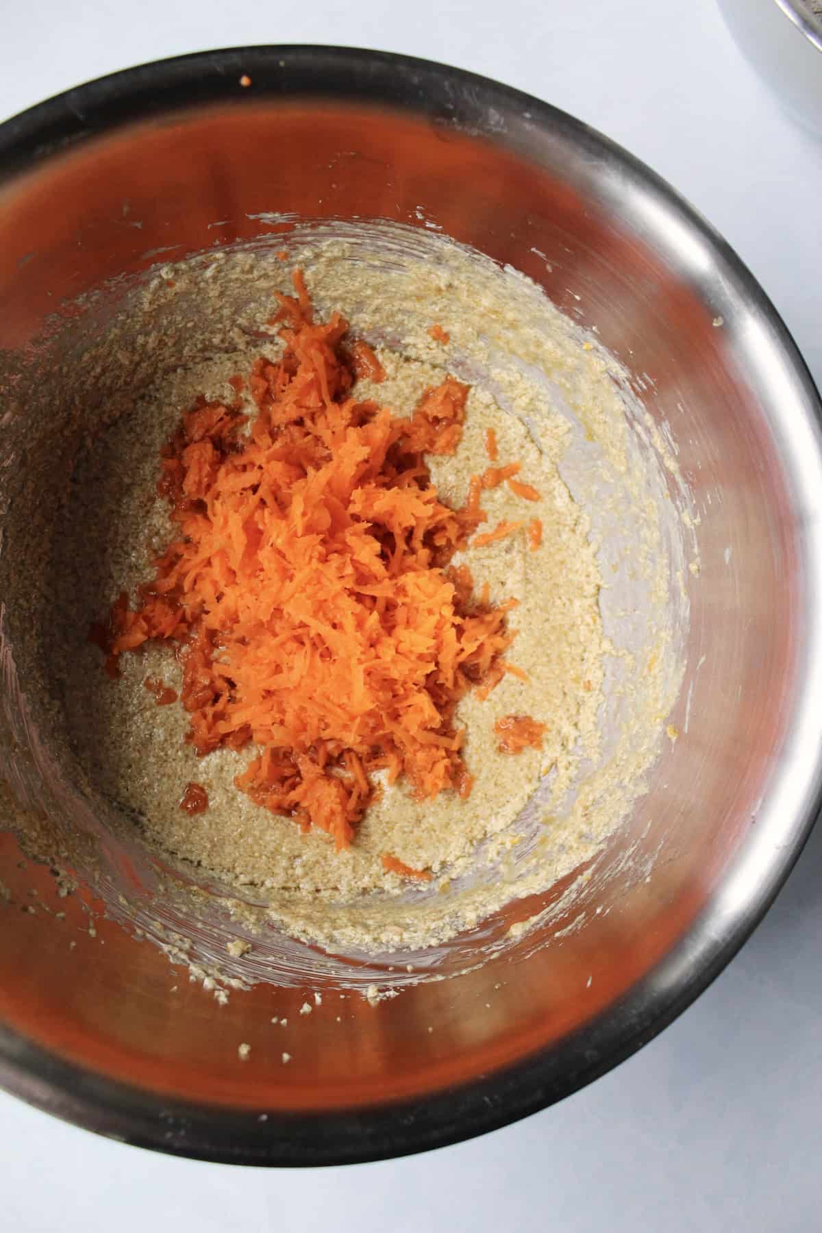the drained shredded carrots are added to the bowl with the wet ingredient mixture
