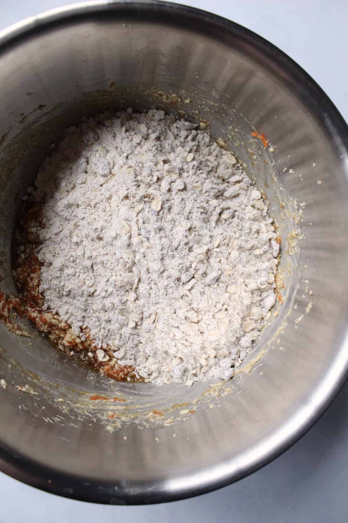 the dry oat mixture is added to the bowl with the wet carrot mixture
