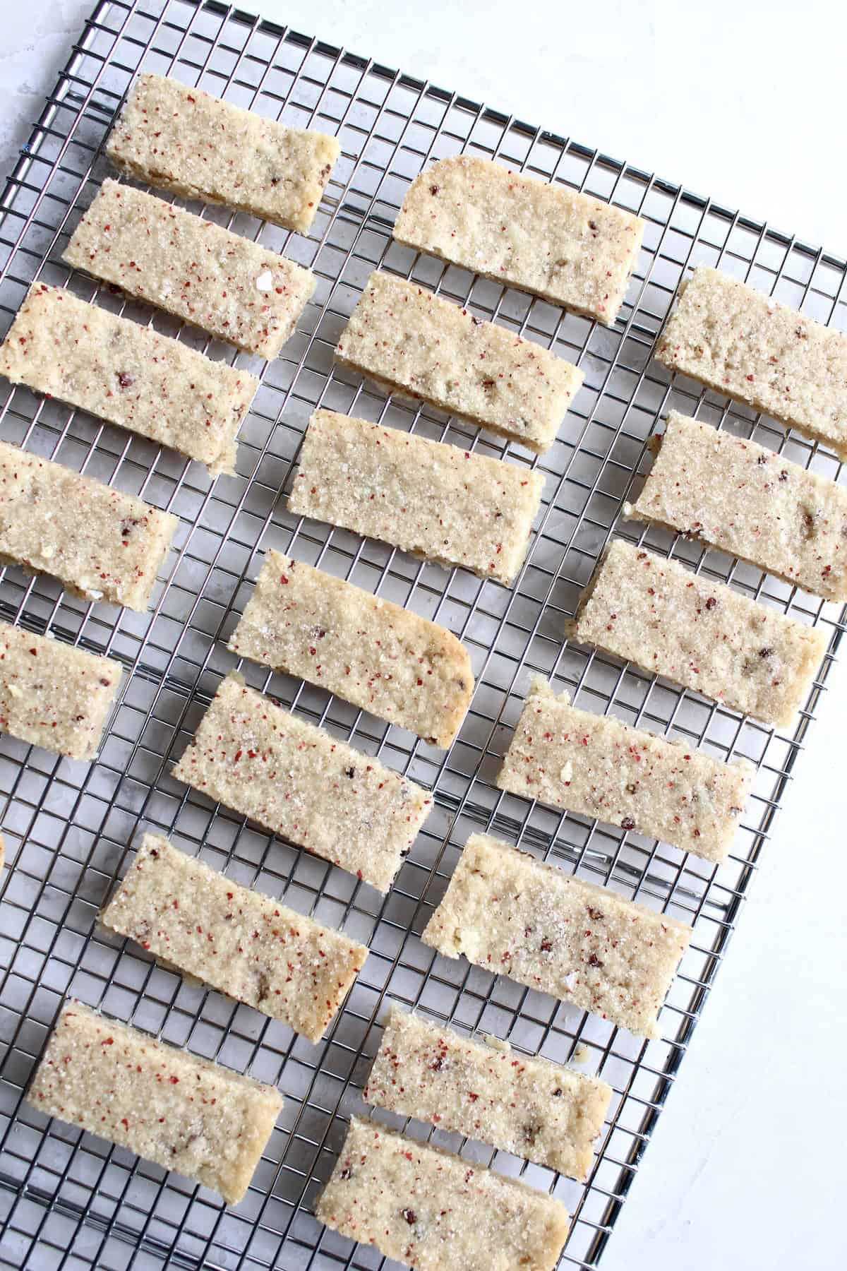 the baked pink peppercorn shortbread cookies are removed from the baking pan and arranged on a wire rack to cool