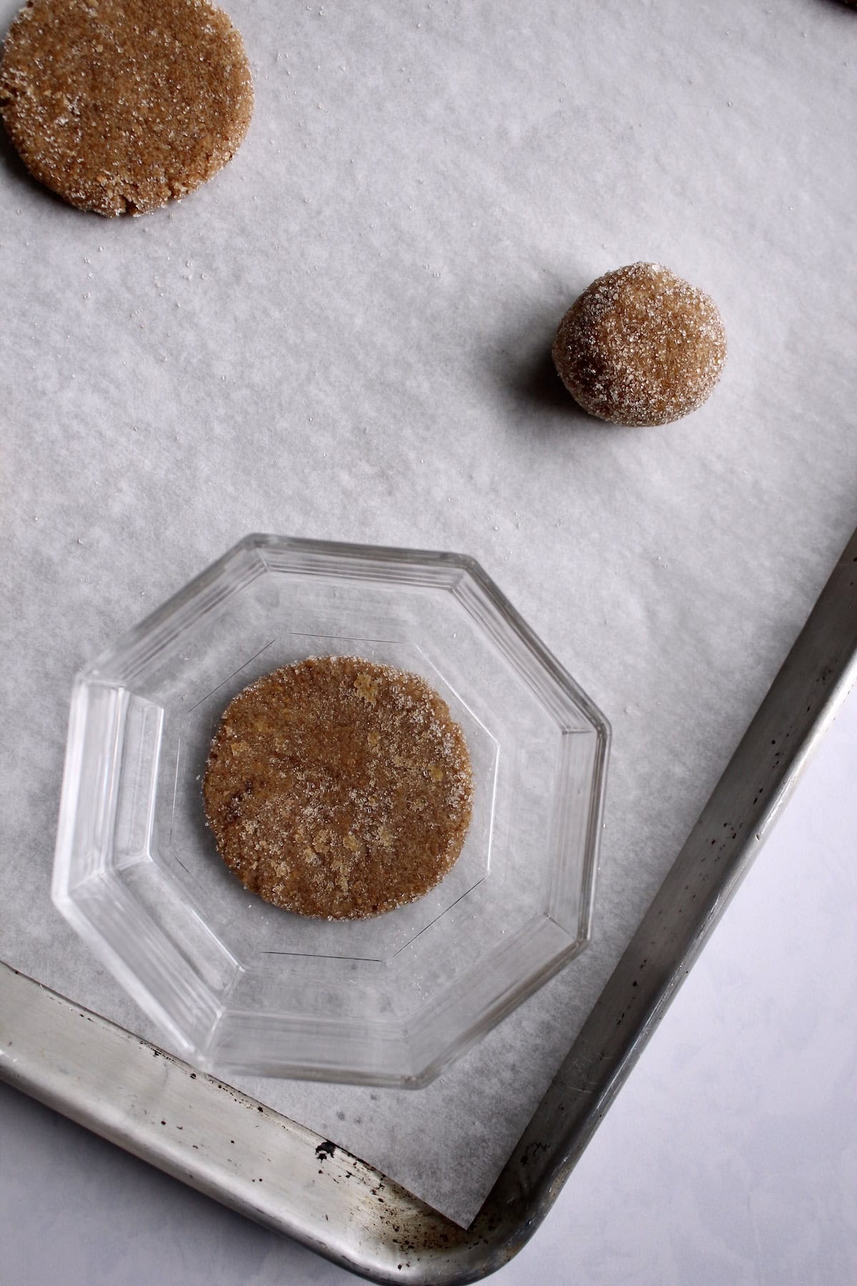 a flat bottomed, clear glass bowl is used to press the dough balls flat.