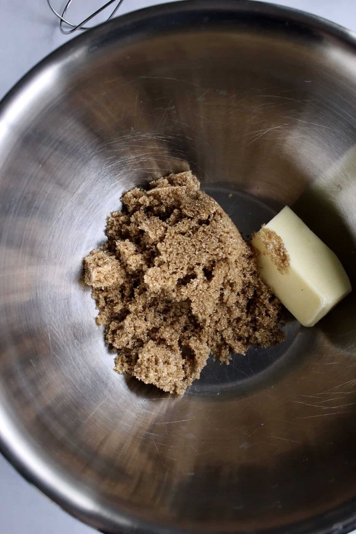 a large mixing bowl containing butter and brown sugar.