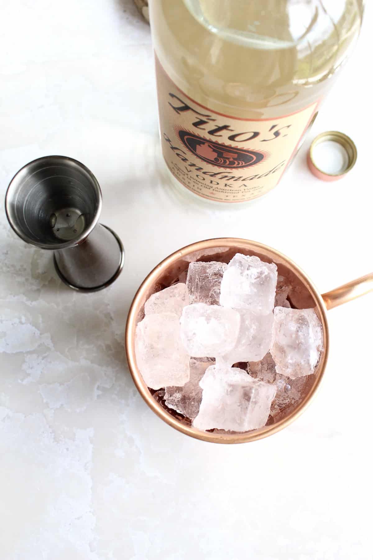 ice cubes are added all the way to the top rim of the copper mug