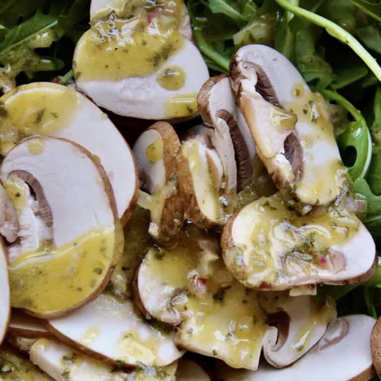 shallot lemon vinaigrette is drizzled over a simple salad of arugula and thinly sliced mushrooms