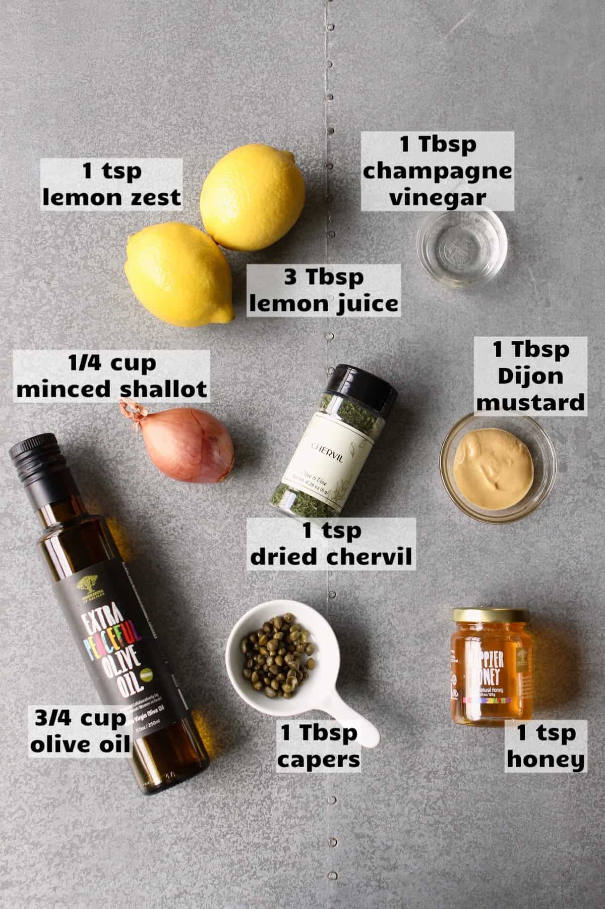 all of the ingredients needed to make shallot lemon vinaigrette are laid out on a work surface and labeled