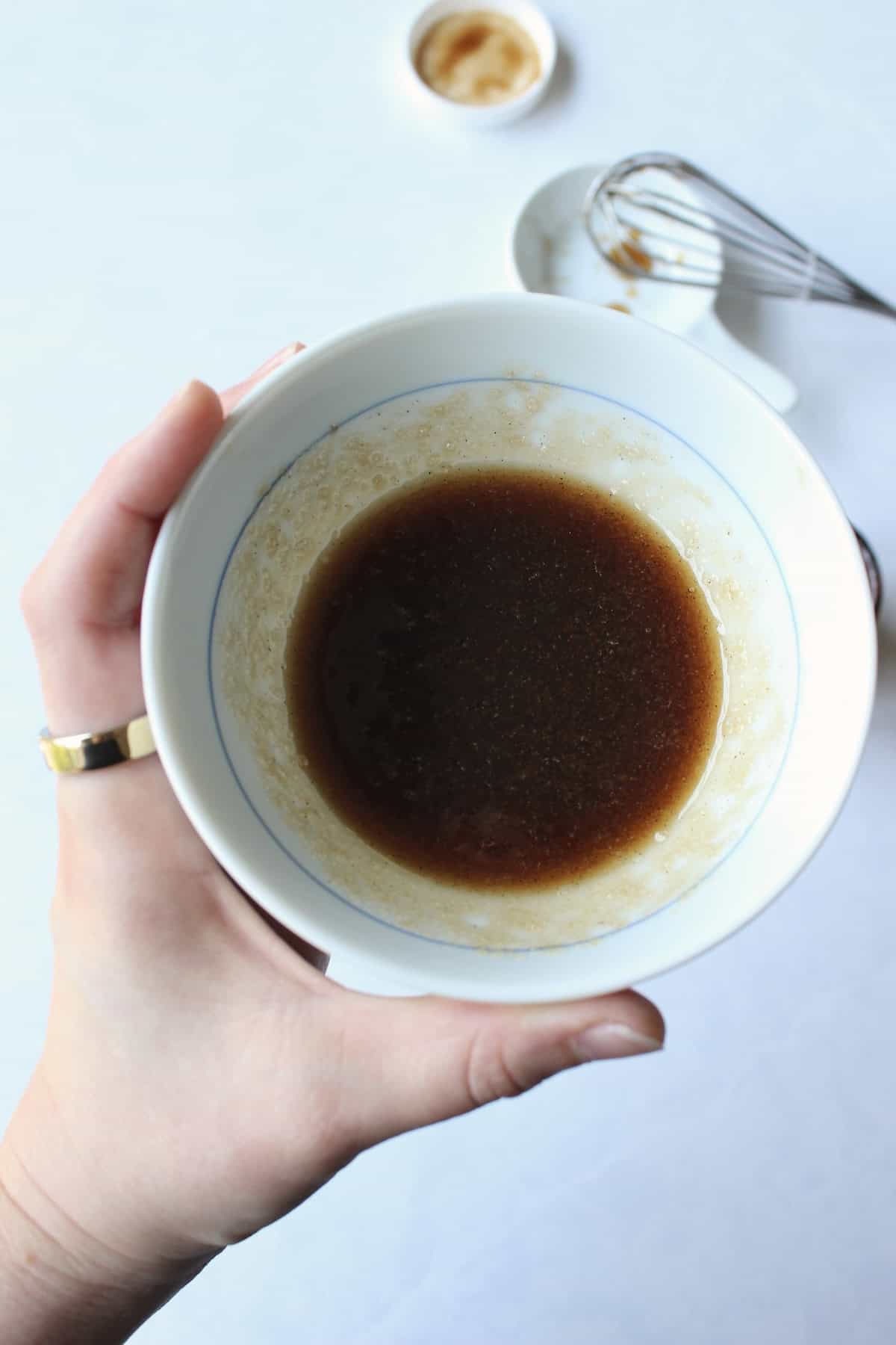 a brown syrupy mixture is stirred together in a small mixing bowl