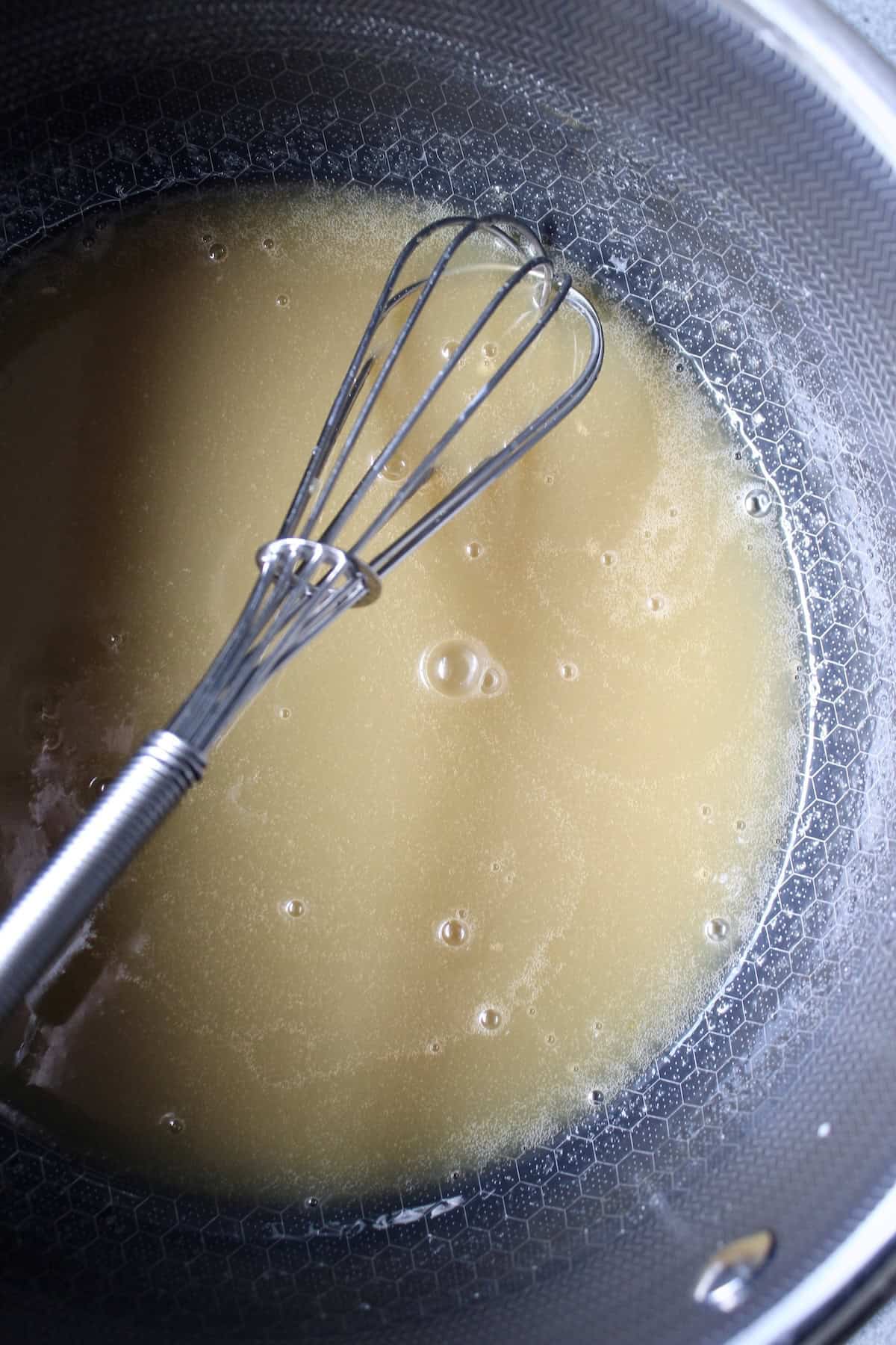 heavy cream is whisked into the pot with the honey mixture