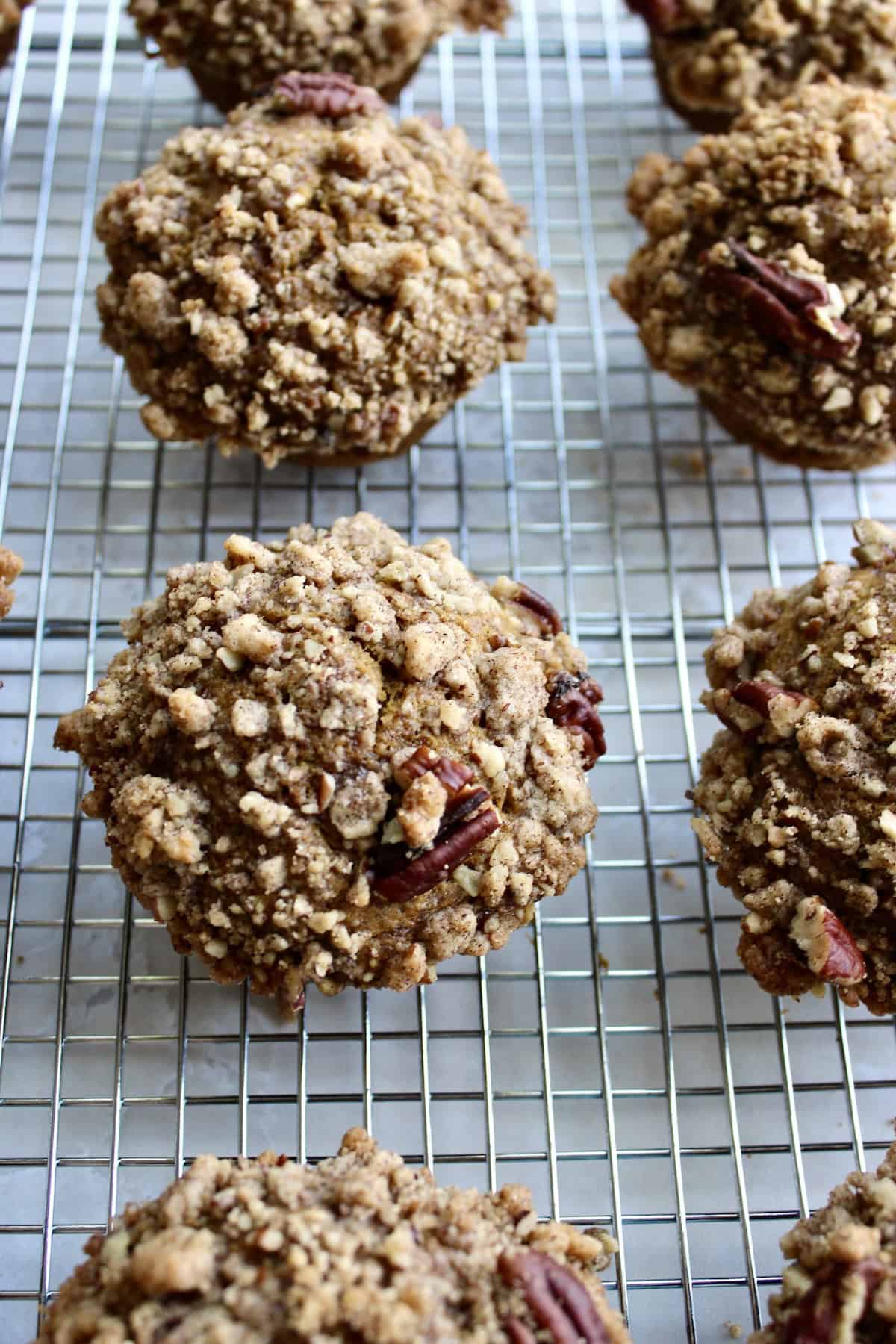the pumpkin muffins with pecan streusel are removed from the baking pans and arranged on wire racks to cool