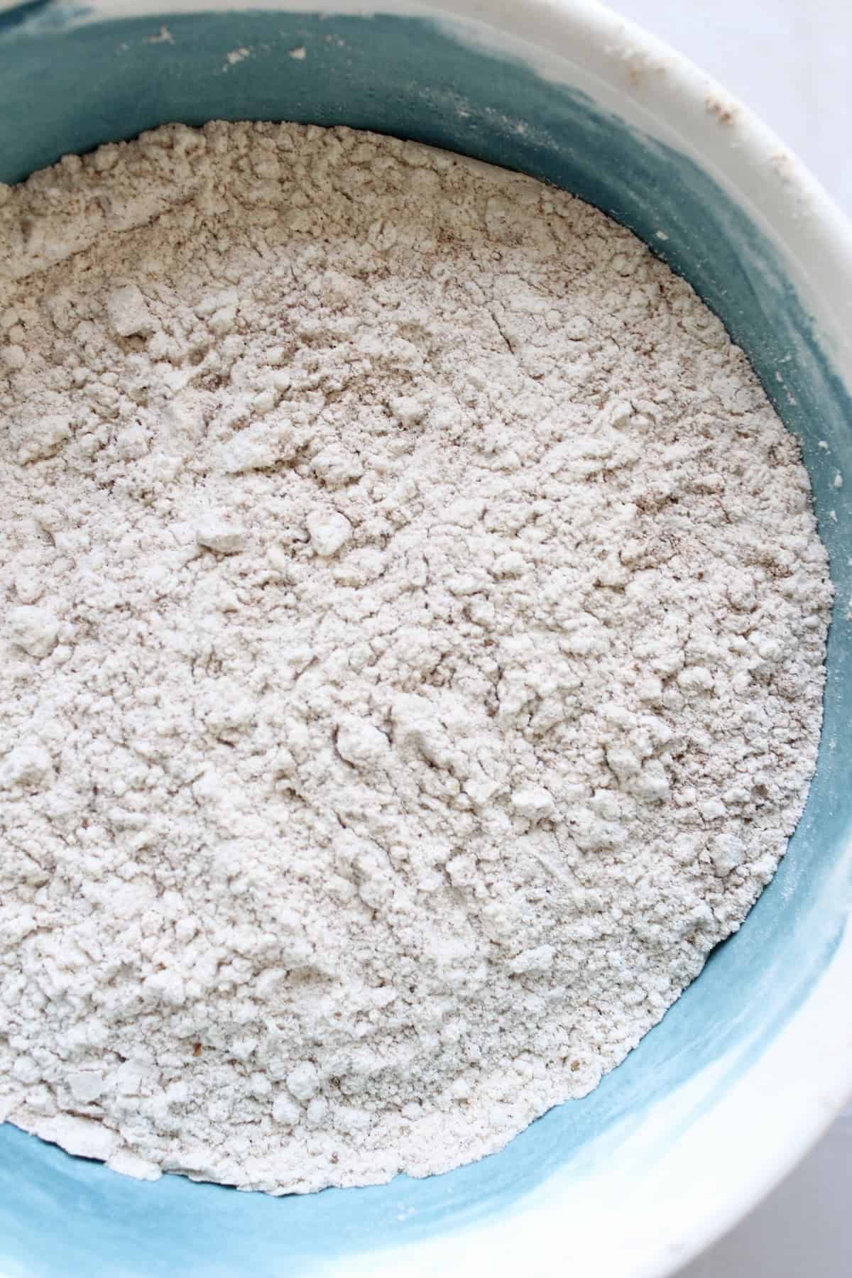 flour, leaveners, and spices are whisked together in a mixing bowl.