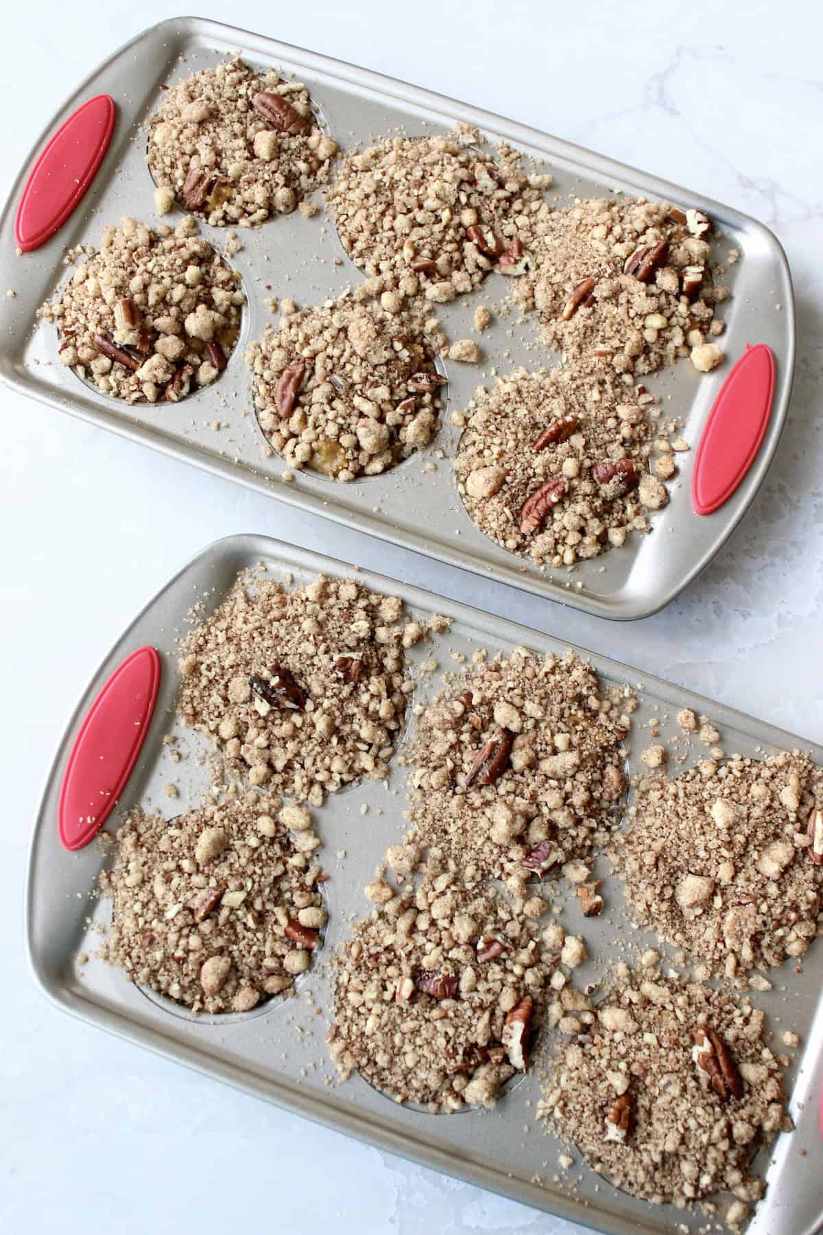 pumpkin pecan streusel topping is added to the top of each cup of muffin batter