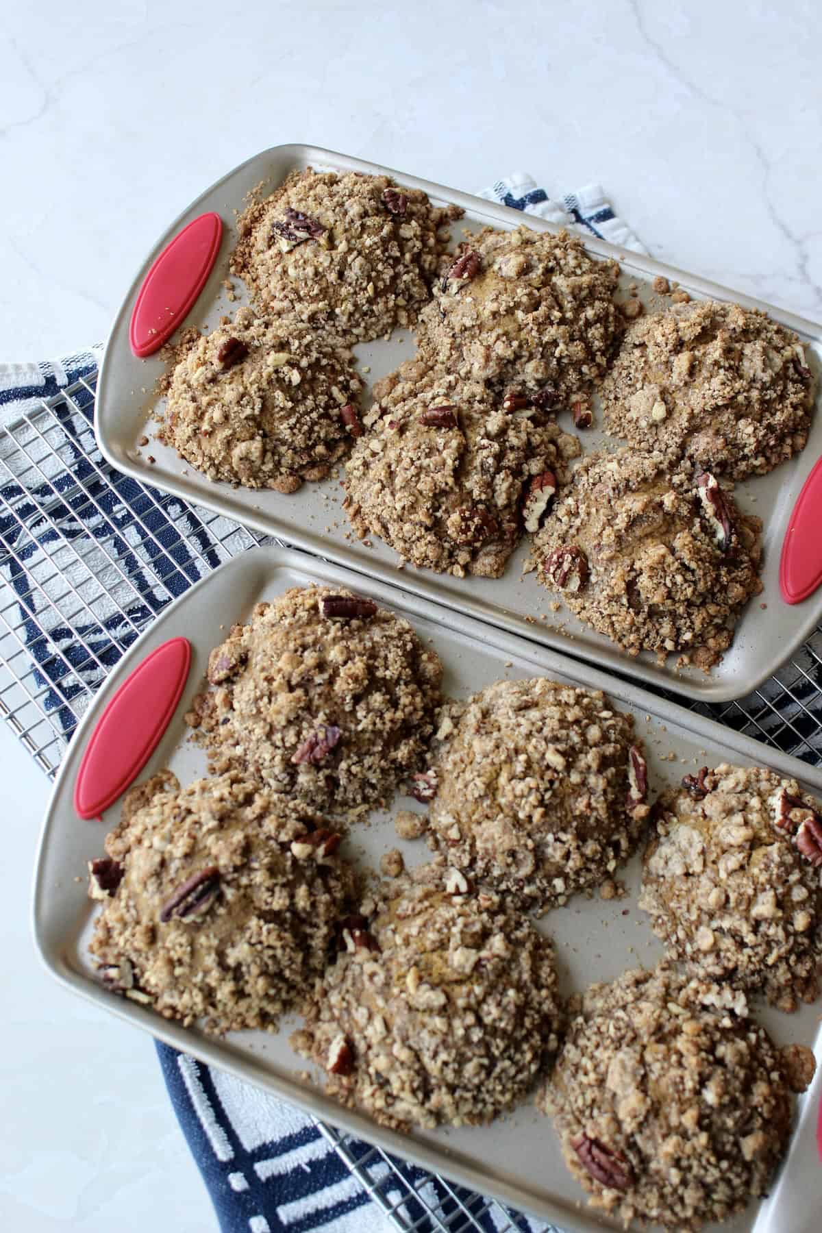 the baked pumpkin pecan muffins are removed from the oven and set on a kitchen towel