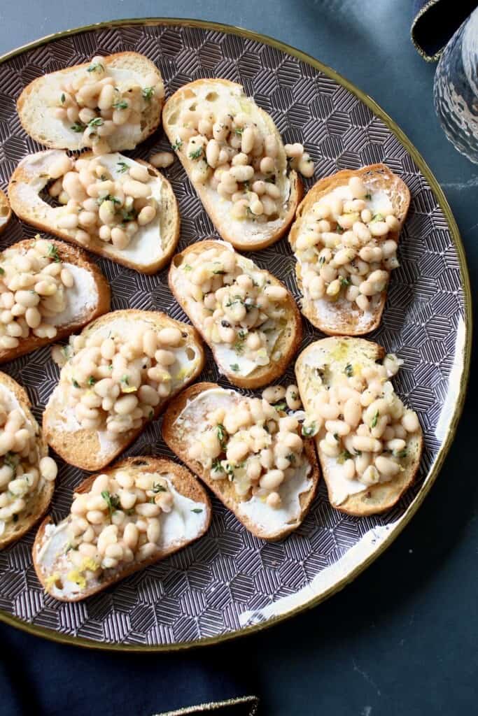 the white bean bruschetta is assembled and arranged on a serving platter.