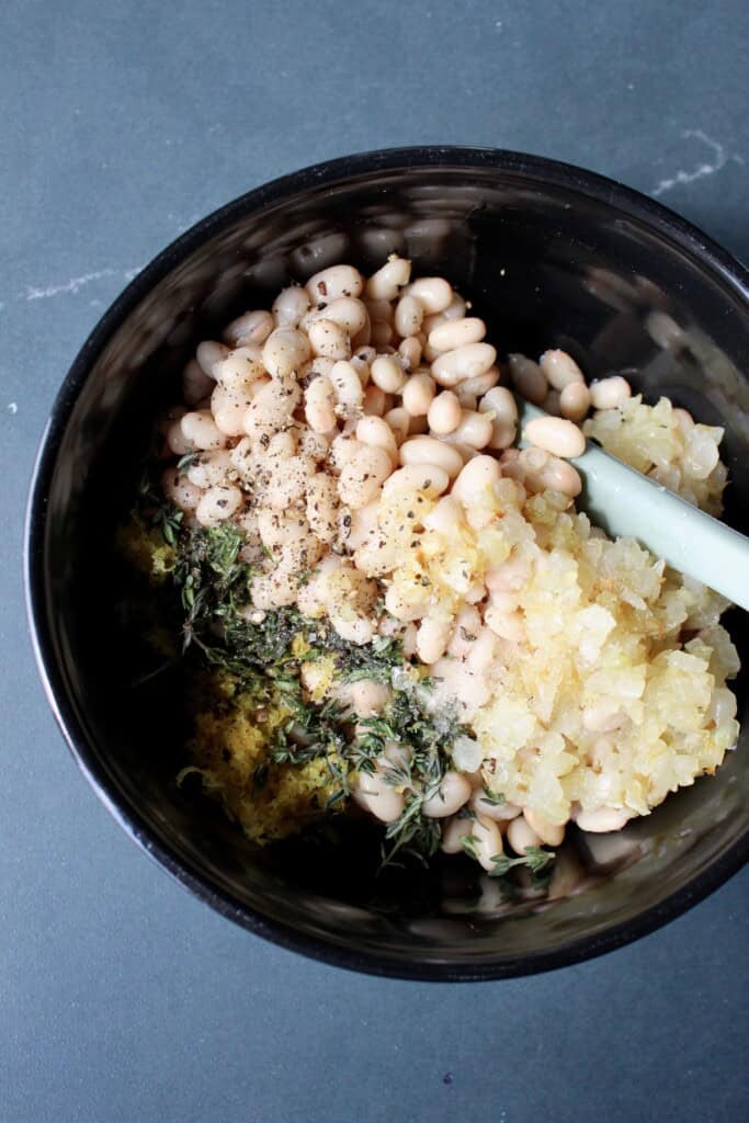 white bean bruschetta ingredients are combined in a mixing bowl.