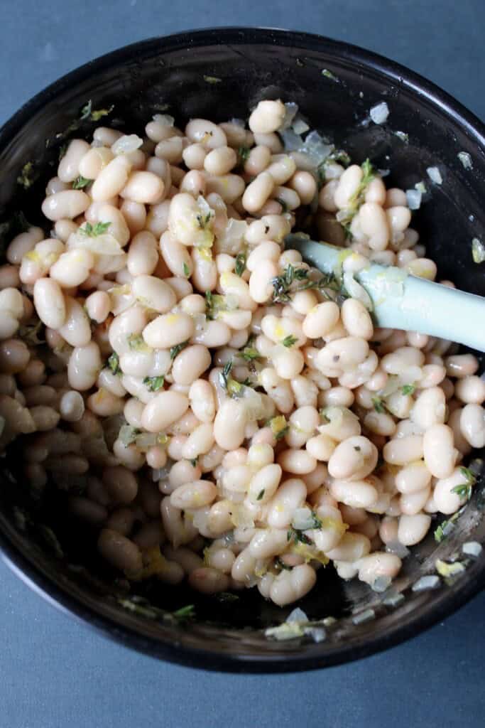 the white bean bruschetta mixture is stirred together.